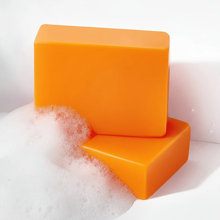 Two orange soap bars with bubbles on a white background