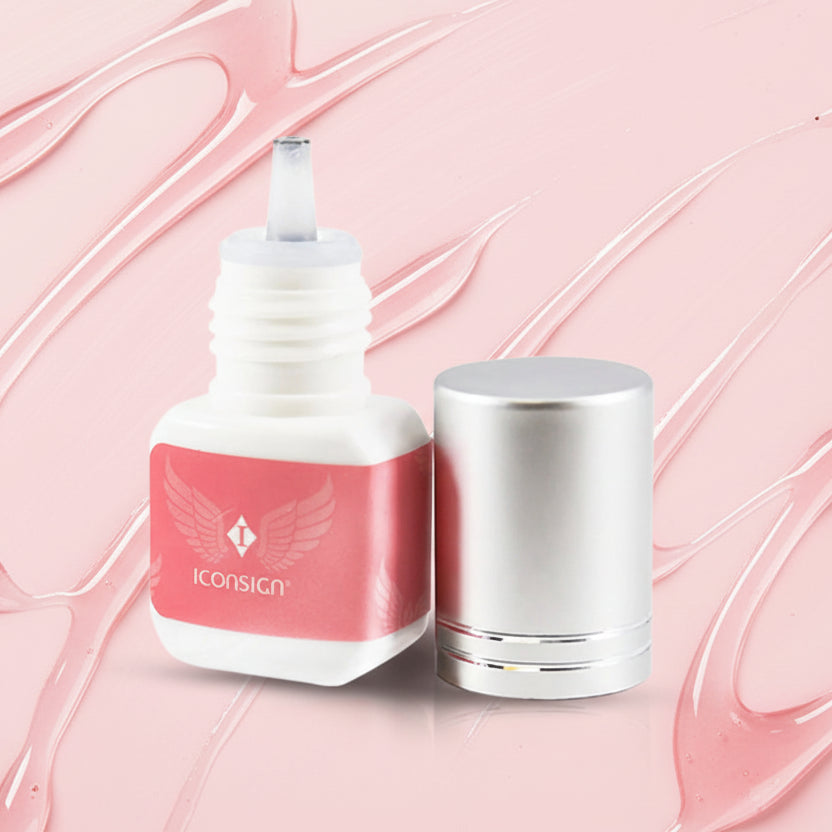 Cosmetic bottle with pink label and silver cap on a white background