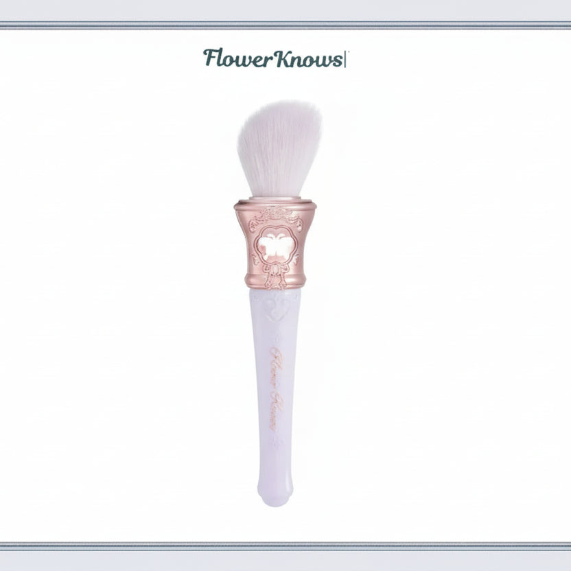 Makeup brush with decorative handle on a light blue background, featuring the brand 'Flower Knows'.